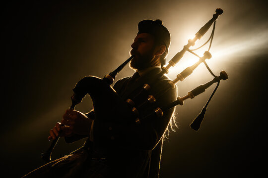 Bagpiper playing bagpipes with dramatic backlight and lens flare
