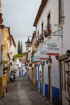 Typical narrow street with portuguese style historic buildings inside the city walls of Obidos, Portugal