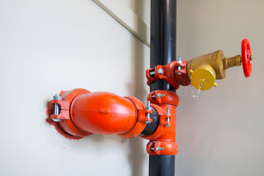 Fire sprinkler riser pipe with hose valve and orange couplings