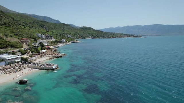 Explore the breathtaking Adriatic coast of Vlore, Albania, featuring lush green hills meeting crystal-clear turquoise waters