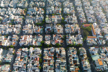 Fototapeta premium A high angle shows densely populated residential and commercial buildings with colorful roofs situated along a grid of streets