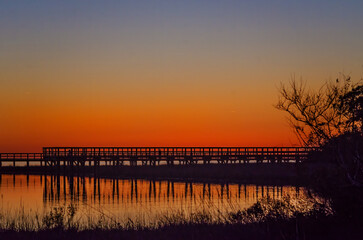 Fototapeta premium Sunset at Aloe Bay observation pier in Dauphin Island Alabama