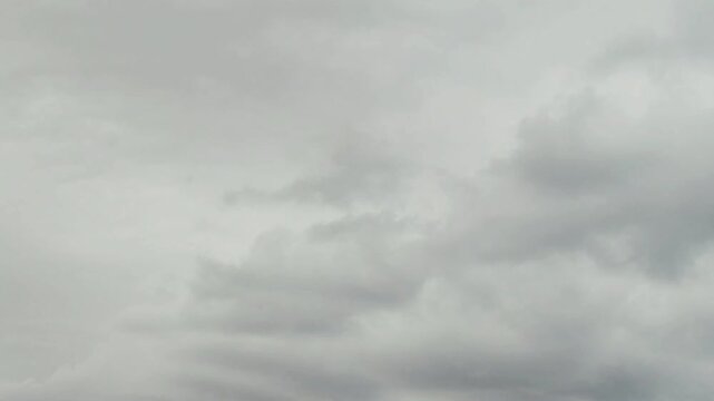 Deep blue sky holds heavy dark clouds. Large rainy shapes move across a wide view. Thick white layers mix with gray storm banks. Thunder may come soon. Wind pushes big formations slowly.