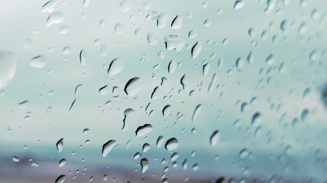 Water drops, Rainy water drops on Window glass screen. Clear water droplet, Raining water drops. 
Droplets bead on a surface. Falling drizzle marks the screen. Bright liquid droplets form on glass. 