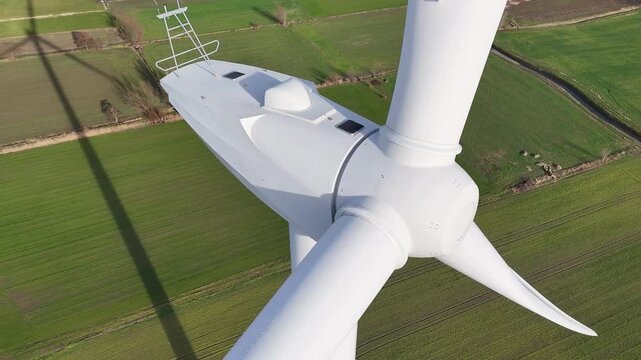 wind turbine nacelle blades cast shadows divided green fields scale environmental impact renewable energy rural landscapes long technology infrastructure 