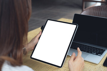 Mockup blank screen digital tablet, woman hands holding tablet with empty screen during working at...