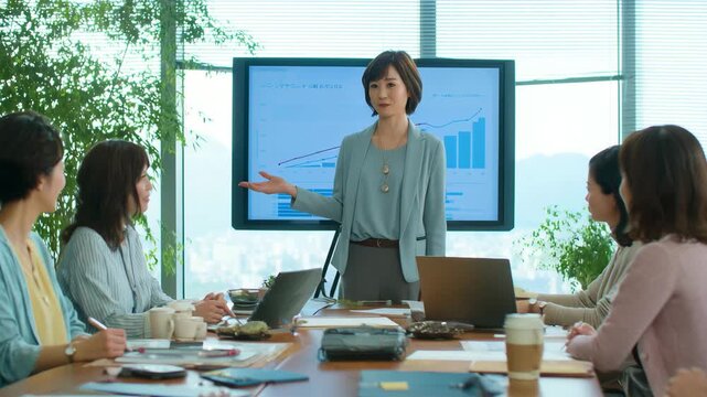 女性がグラフで説明するミーティングの様子
