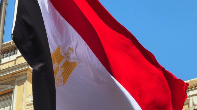 Close Up of National Egyptian Flag Waving over Neoclassical building Facade