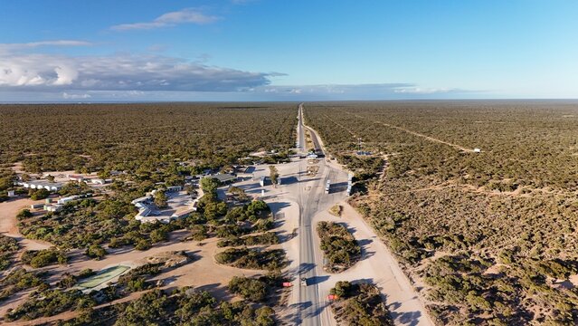 Border Village between South Australia and Western Australia, Nullarbor Plain &ndash; 4K aerial drone view of remote roadhouse, Eyre highway, border control, Vehicles, outback highway and vast wilderness