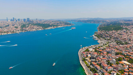 Fototapeta premium Istanbul, Turkey. Panoramic aerial view of Bosphorus Strait with ships sailing between Europe and Asia on clear sunny day. Aerial View