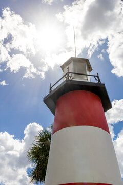 A striking lighthouse against a sunlit sky at Gilbert Park, Mount Dora, Florida.