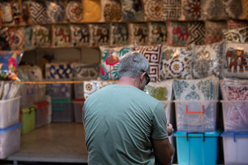 Obraz premium Senior man sitting resting in market, casual urban walking Thailand, human presence in urban environment, public life concept, rear view, Chatuchak