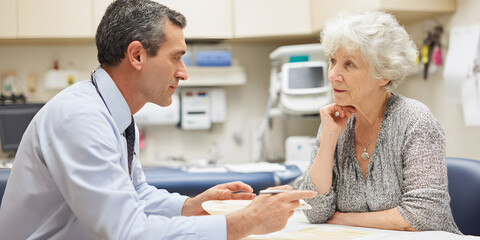 Obraz premium Professional male doctor is explaining medical results to elderly female patient. Healthcare concept