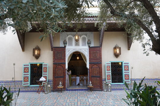Traditional Moroccan riad entrance with ornate arch and wooden doors in Marrakech Medina