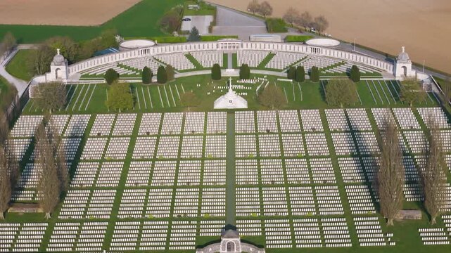 vast military tyne cot cemetery arranged strict white headstone grid set bright green lawns central path runs stone arch cross sacrifice memorial wall engraved to from wwi zonnebeke 