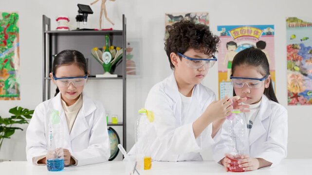 Asian Children in Lab Coats Conducting Science Experiment with Balloons and Bottles