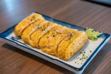 Tamagoyaki, a Japanese omelette made by rolling together several layers of fried beaten eggs,...