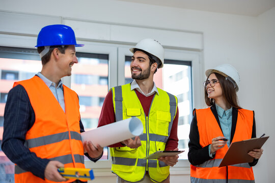 Construction team in safety gear talking and looking at each other.