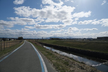 Fototapeta premium 3月の空と川辺の道その1