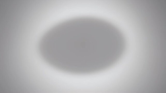 Blurred gray circle on radial light-to-dark gradient background, with soft halo