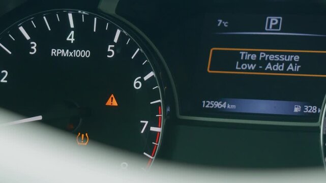 Low tire pressure warning light on digital car dashboard