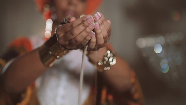 African priestess holding sand in hands, grains of sand pouring through fingers. Time fly and life is not infinite, dream of eternity, ritual and culture of african people, amazing golden jewelry