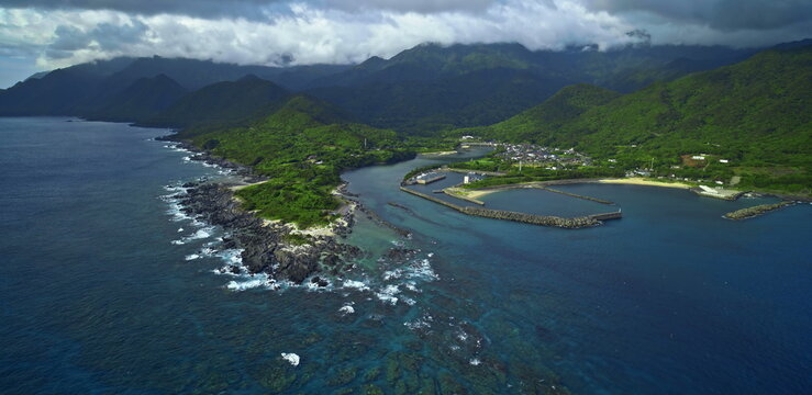 Coastal harbor with green mountain backdrop