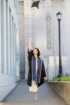 Joyful university graduate throwing cap to celebrate achievement