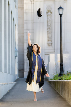 Joyful Berkeley graduate tossing cap in celebration of achievement