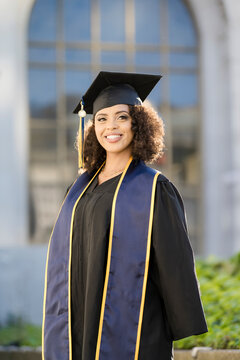 Smiling Berkeley Graduate in Cap and Gown on Campus
