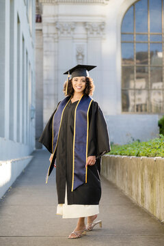 Berkeley Graduate Walking in Cap and Gown on Campus Path