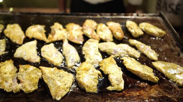 Authentic crispy tawa fish fry garnished with fresh lemon and coriander, prepared on a rustic iron tawa in India.