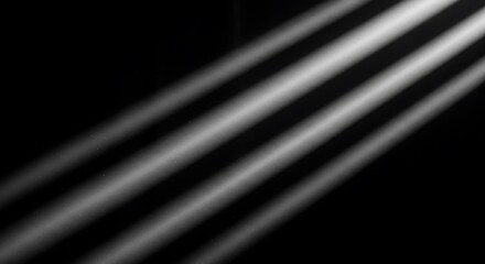 Fototapeta premium Diagonal beams of white light shine through darkness with floating dust particles