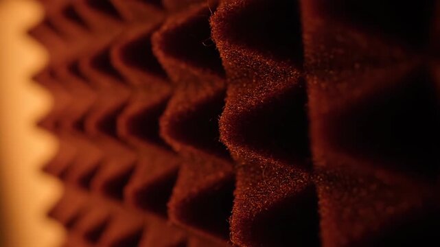 Close-up of red soundproofing foam panel, acoustic treatment, background, sound absorption, studio equipment for sound recording.