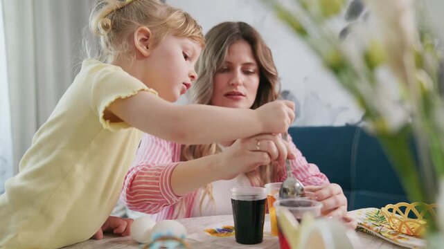 Child and mother share joyful moment over drinks