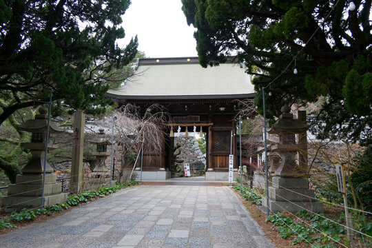 The historic East Gate (Shinmon) and stone lanterns of Yasaka Shrine in Kitakyushu, Japan.