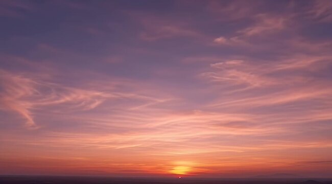 Vibrant sunset sky showcasing a colorful gradient from purple to fiery orange with soft clouds