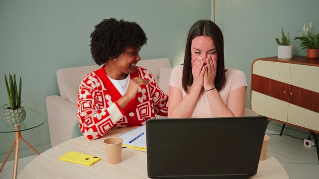 A joyful moment captured as two friends engage in a delightful video chat on a laptop, sharing laughter and happiness through technology, enhancing their connection despite the distance.