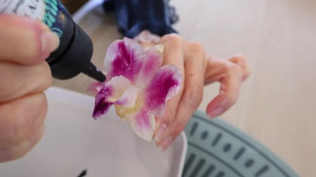 Footage of Orchid Flower Being Applied Resin in Multiple Layers during Crafting Process of DIY Workshop	