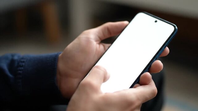 Close-up of Hands Holding Smartphone with Blank Vertical White Screen Mockup for Mobile App and Web Design