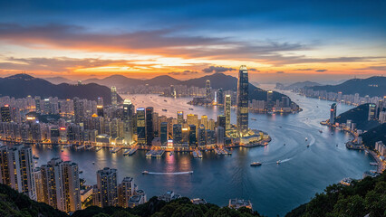 Naklejka premium Panoramic view of Hong Kong skyline during sunset over harbor