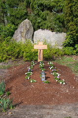schöner schlichter Grabhügel mit einem Holzkreuz auf einem Friedhof in Unna © Blende8