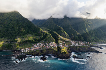Seixal village built along steep cliffs on Madeira Island. Coastal landscape with terraced terrain and the Atlantic Ocean © Leonid