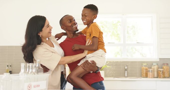 Diverse family child squirming red-shirt father holding, mother tickling in kitchen by GLASS crate