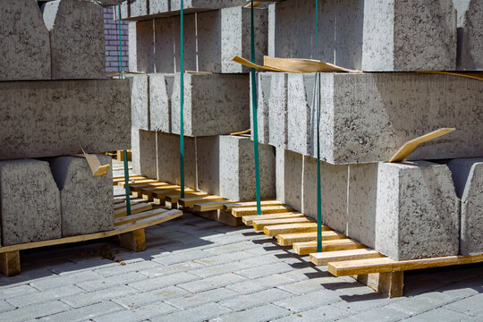 Pack of concrete curbstone stacked and tied on pallet