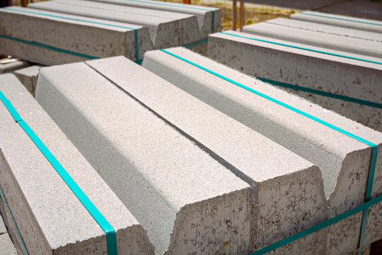 Pack of concrete curbstone stacked and tied on pallet