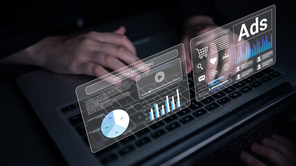 A person interacts with a laptop displaying digital marketing graphs and visualizations, embodying...