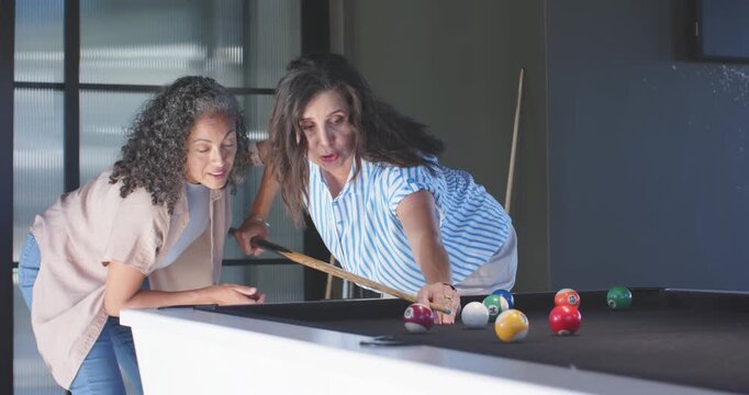 Vertical video: Shooter drawing cue back and striking cue ball on pool table, pal clapping, leisure