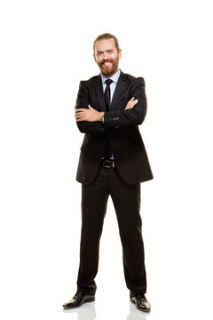 ull body portrait of a confident businessman in black suit with arms crossed. Smiling executive or corporate leader standing against white background, isolated professional male portrait.