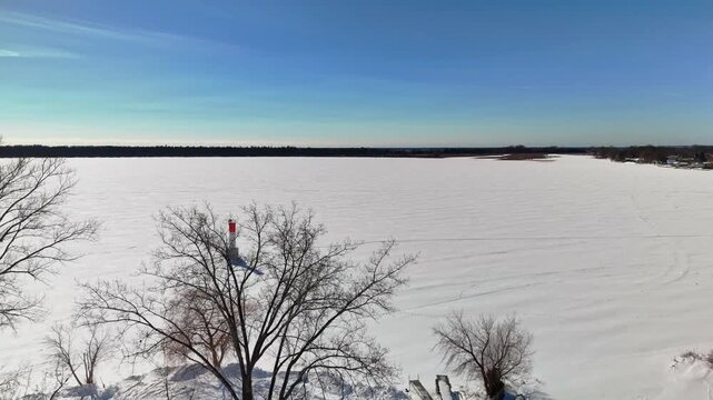 Aerial Drone Dolly Shot of Frozen Lake Covered with Snow and Ice at Gosport in Brighton Ontario Canada